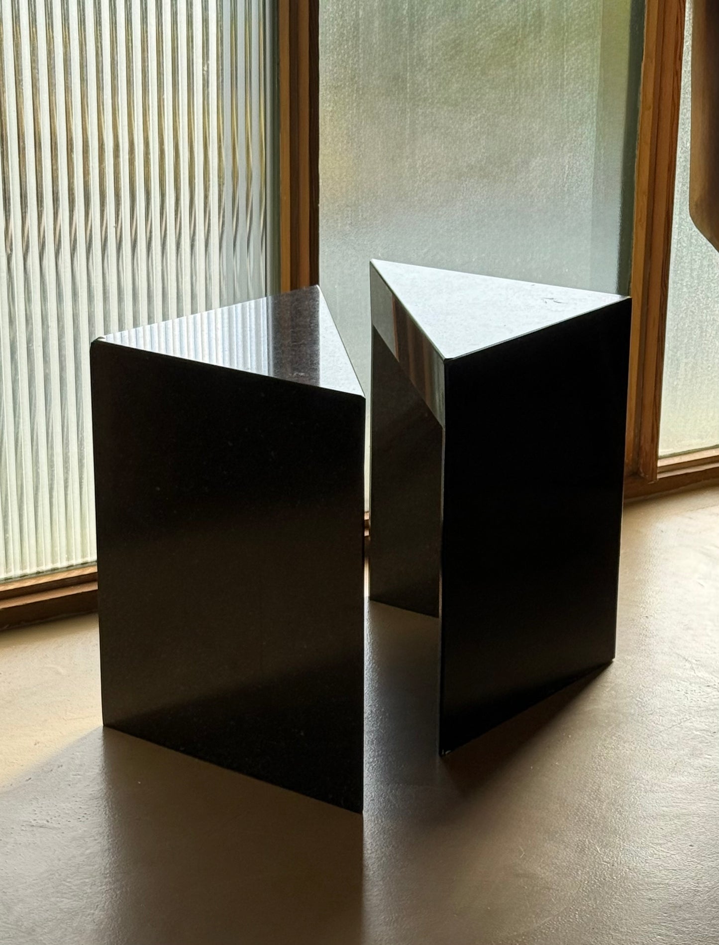 Pair of postmodern black granite triangular end tables, late 20th century