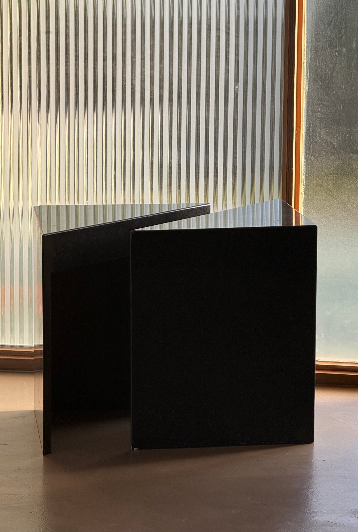 Pair of postmodern black granite triangular end tables, late 20th century