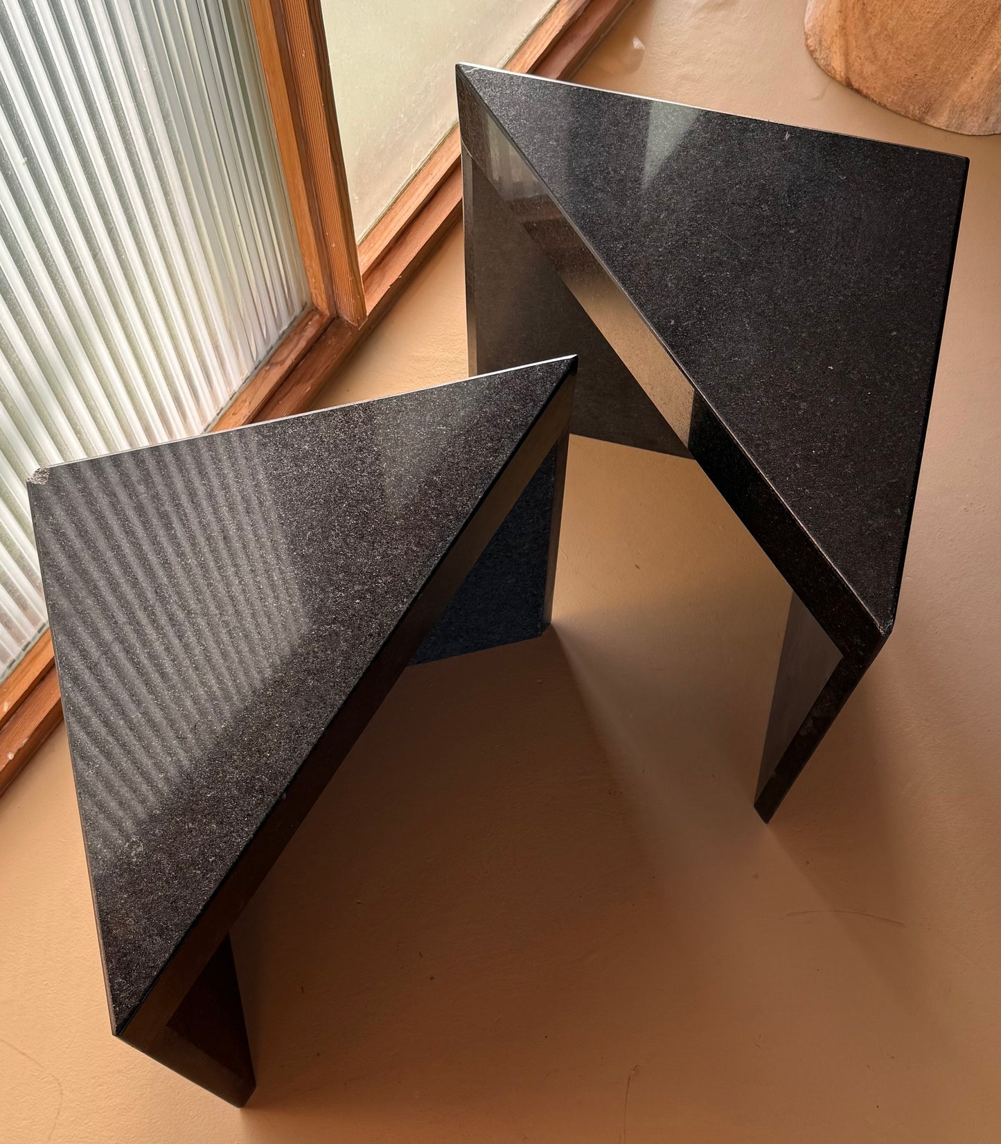 Pair of postmodern black granite triangular end tables, late 20th century