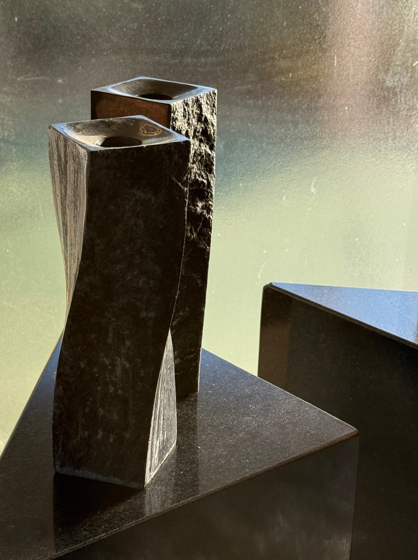 Pair of black stone candlesticks, late 20th century