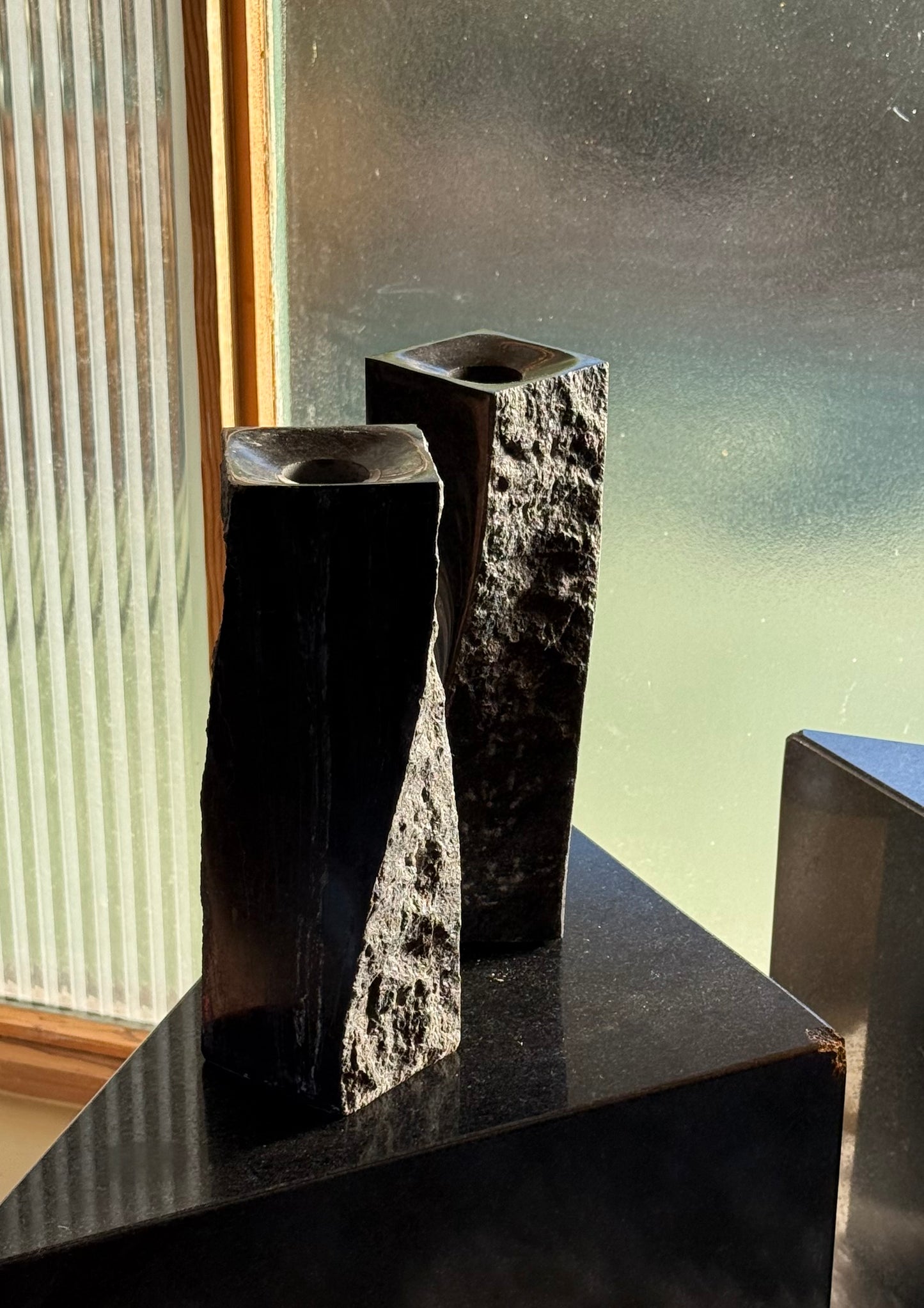 Pair of black stone candlesticks, late 20th century