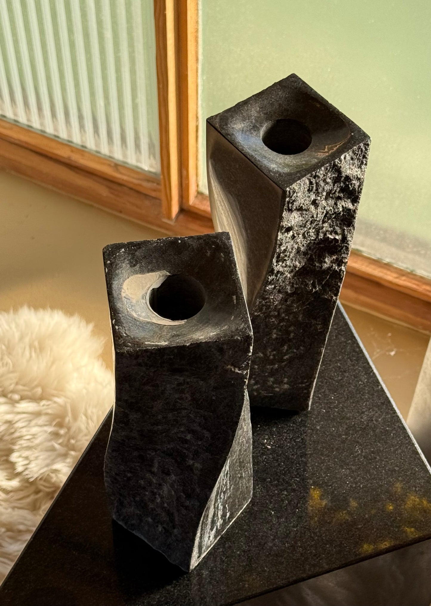 Pair of black stone candlesticks, late 20th century