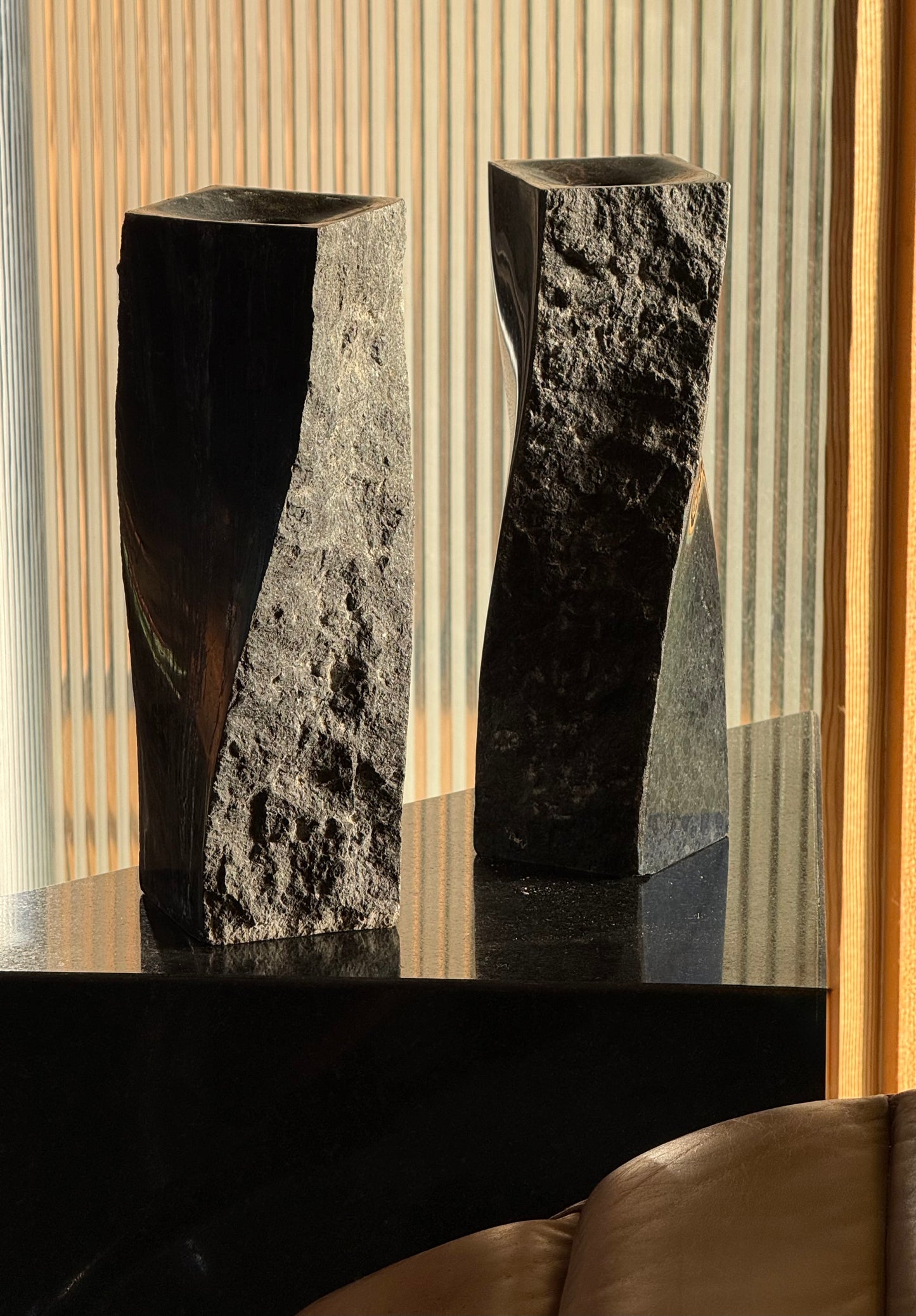 Pair of black stone candlesticks, late 20th century