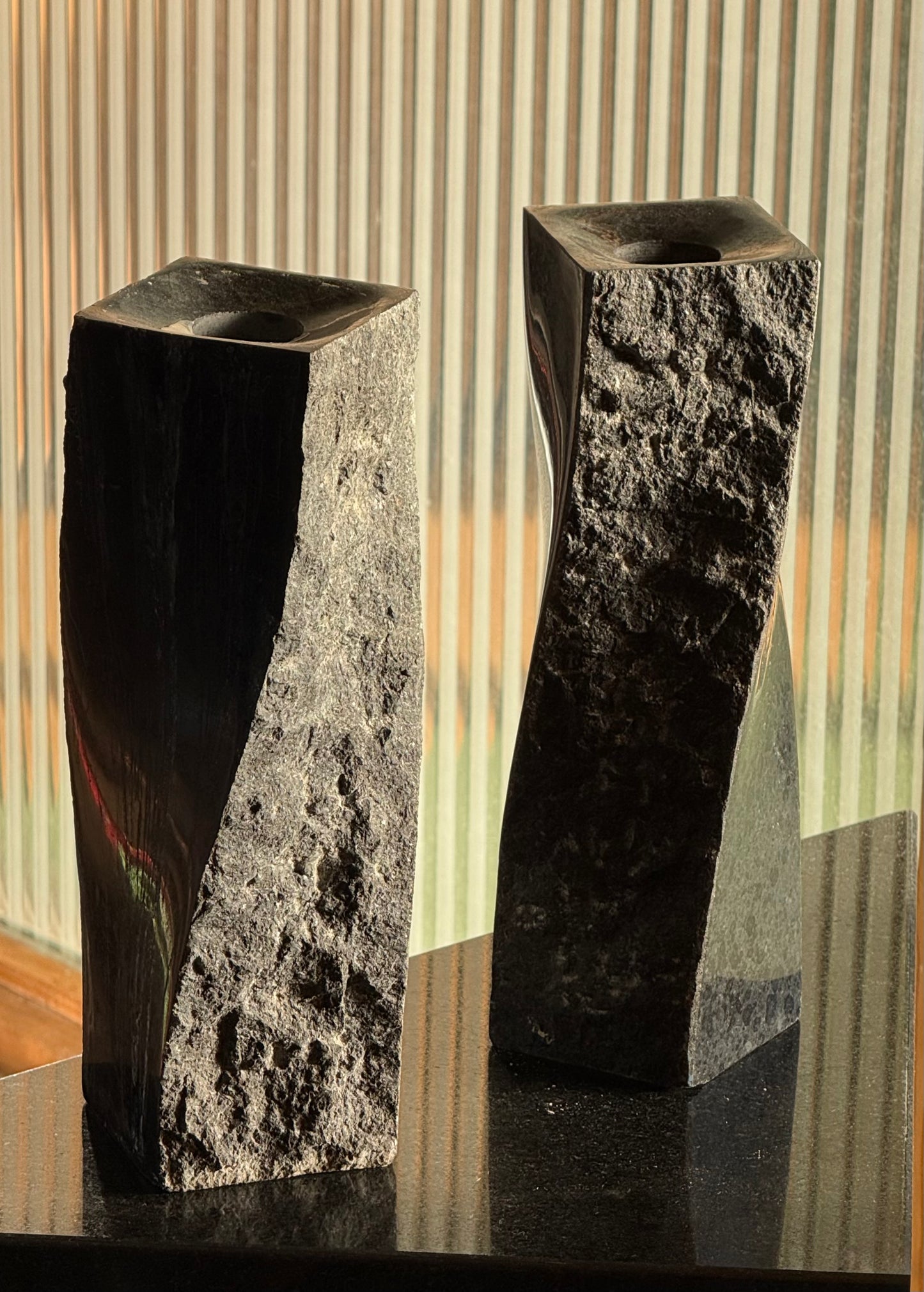 Pair of black stone candlesticks, late 20th century